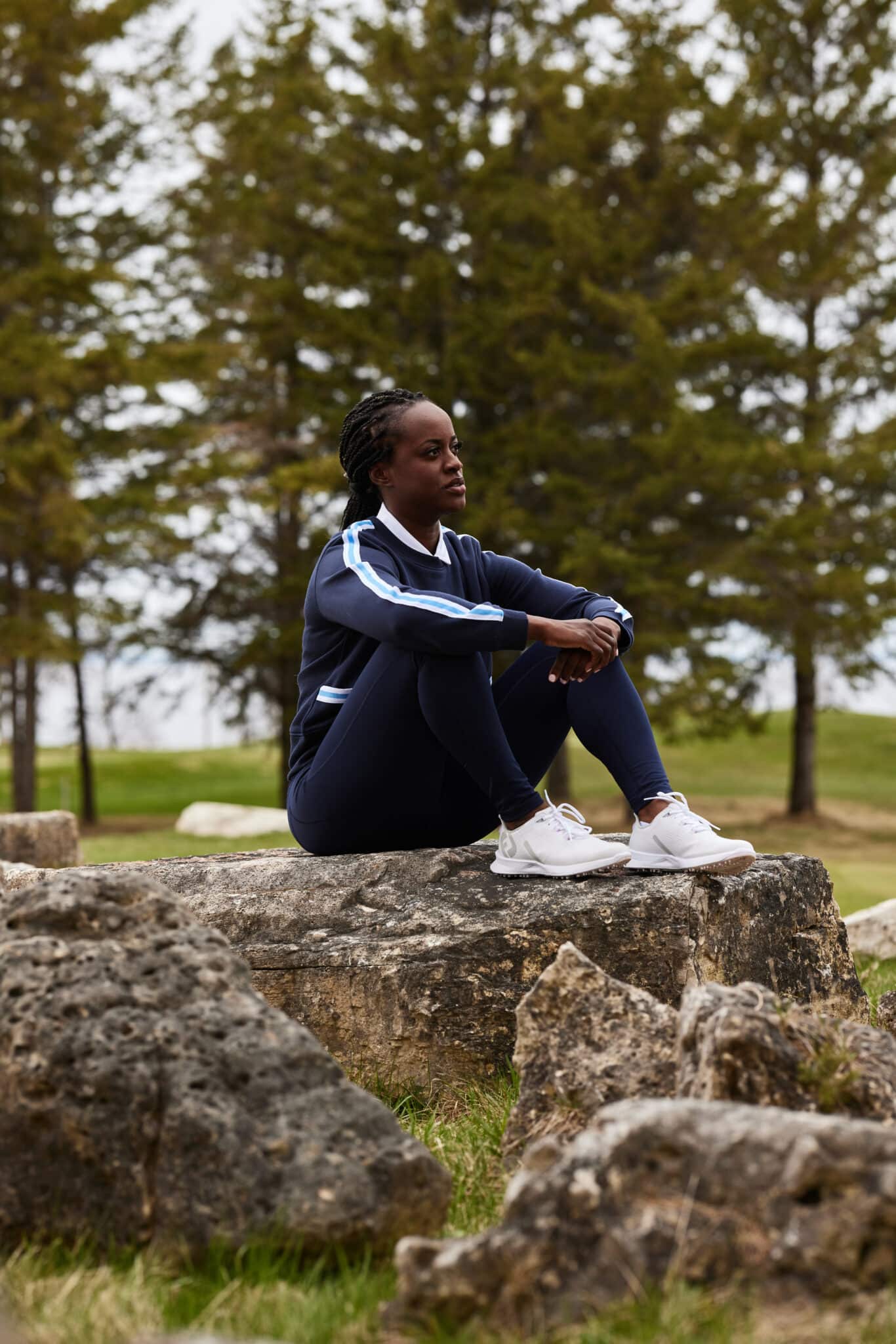 A woman sits on a rock watching her friends play golf. Example of product photography by LA fashion photographer.