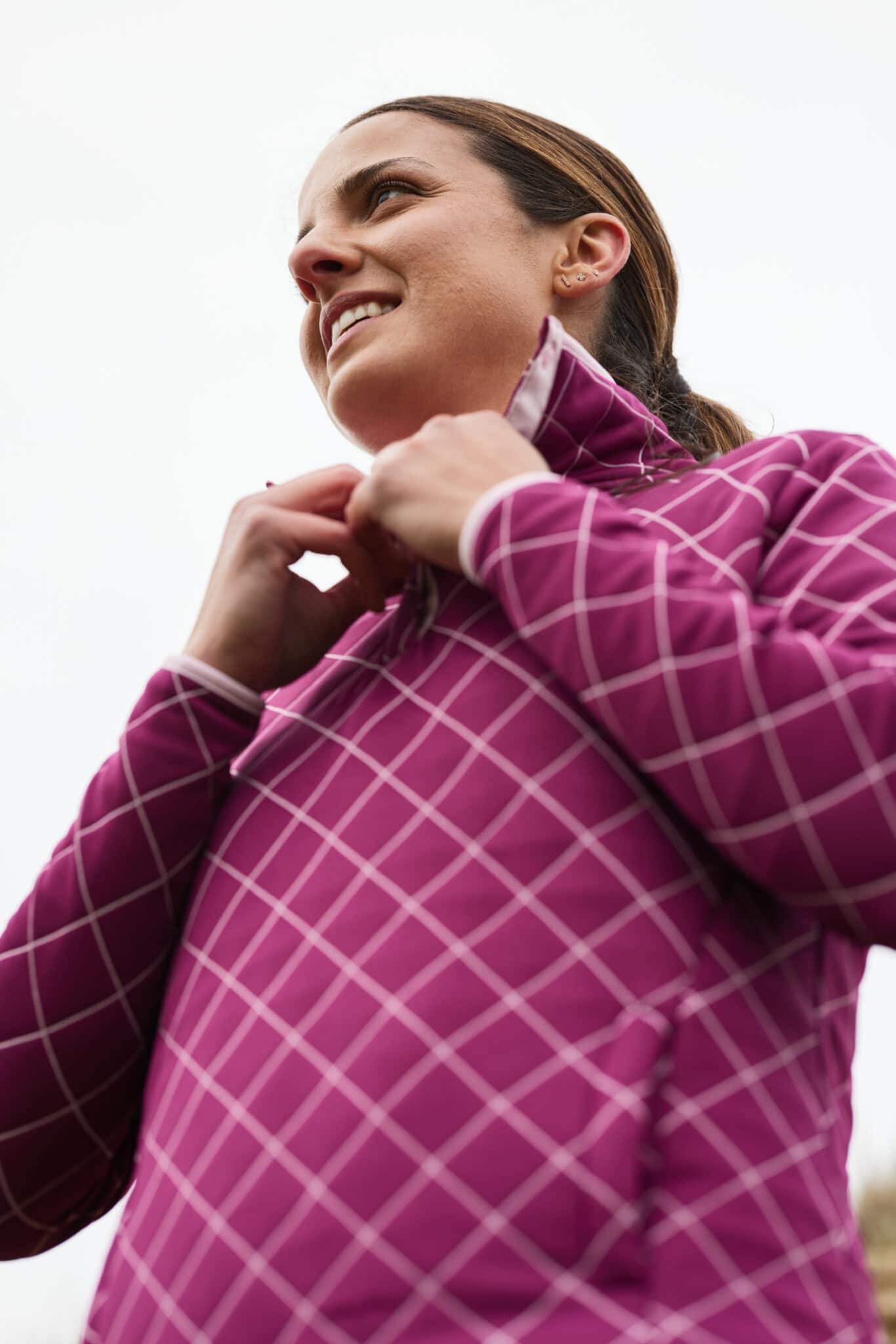 A brightly dressed woman adjusts her sweater in an example of lifestyle fitness photography by LA based photographer Hannah Dunsirn.