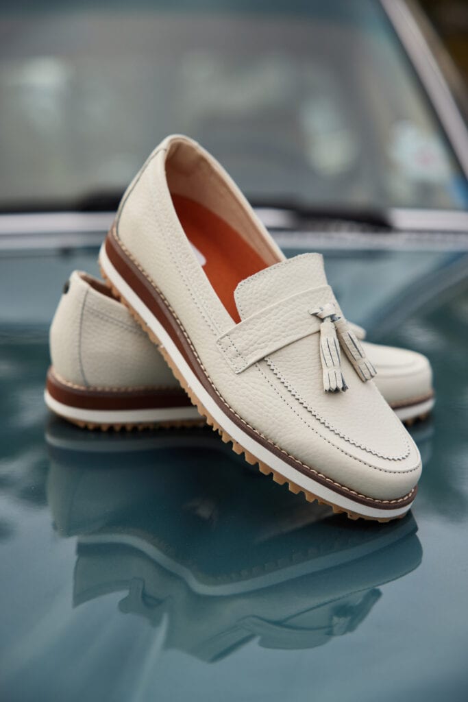 A pair of golf shoes placed on top of a vintage vehicle. Image taken by product photographer Hannah Dunsirn, based in Los Angeles.