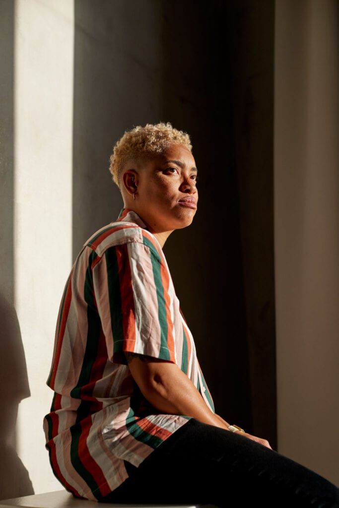 Woman of color in striped shirt gazing into the distance taken by lifestyle photographer in Los Angeles