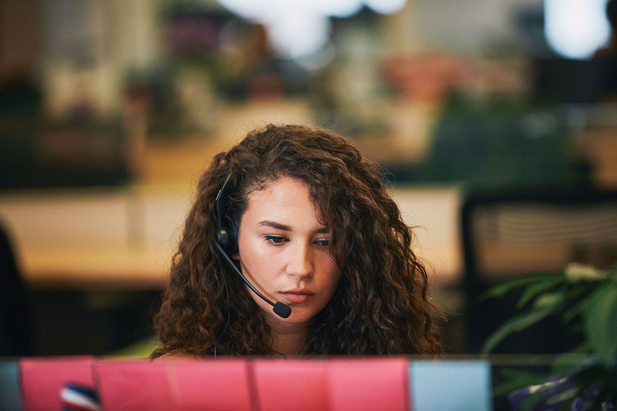 Woman sitting in front of a computer screen wearing a headset taken by a commercial lifestyle photographer in Los Angeles